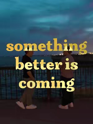 Two people are standing facing each other on a pier or a walkway with a body of water in the background. Overhead, the sky is painted with streaks of colors from a sunset. Prominently displayed over the image are the words 'something better is coming.'