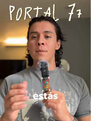 A medium shot features a man with dark hair, holding a microphone. Above his head, white text says 'PORTAL 77.' Below him, the word 'estás' is superimposed over the image in white font.