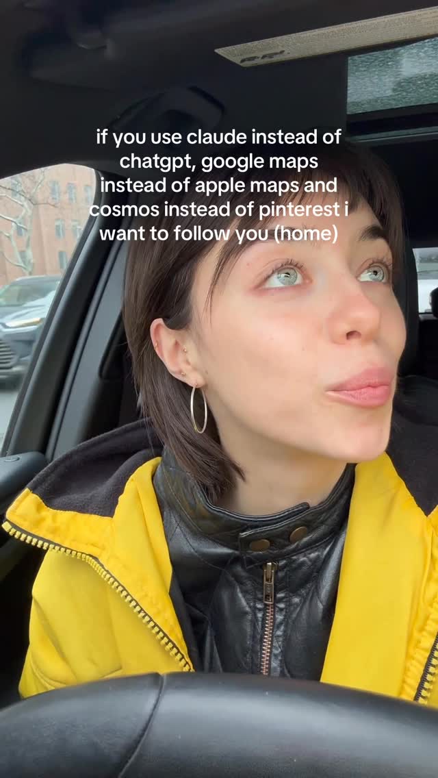 A woman with blue eyes, wearing a yellow jacket and a black leather jacket, is sitting in the driver's seat of a car. The window is slightly open, and the background shows buildings and the outdoors. Text overlayed on the image has a call to action.