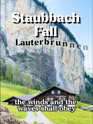 The image captures a picturesque landscape with a cascading waterfall as its centerpiece. The waterfall, framed by a towering rock formation, adds a dramatic contrast to the green and lush vegetation below. At the foot of the cliff, there's a charming house. Overlayed text at the top reads \"Staubbach Fall Lauterbrunnen,\" while at the bottom, \"the winds and the waves shall obey\" is written, suggesting an appreciation of natural beauty and inner peace.