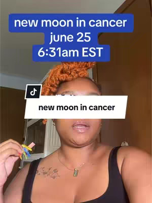 A vertical video cover shows a woman with orange hair and a black top, centered in the frame. Above her are two blue rectangles with white text indicating astrological details. The woman's face is partially covered by a white banner that blocks her under eyes, but the banner contains the phrase, 'new moon in cancer'. The background is a soft, neutral tone, and a TikTok logo is visible. She is holding her hand close to her face with colorful nails.