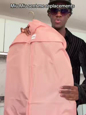 A person is holding a pink garment bag over pink, and white background. Text is at the top of the frame.