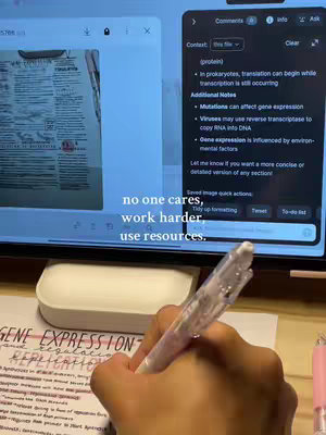 A person's hand holding a pen, writing notes with highlighted sections on a sheet of paper. The shot shows a tablet screen displaying study notes and additional information. The background is cluttered with study materials along with a pen and a pink highlighter. The image is bright and well-lit, suggesting a study environment.