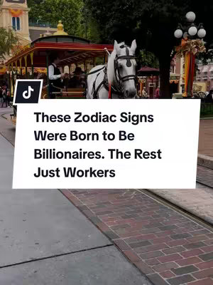 A horse-drawn carriage travels down a city street. In the foreground, a brick and cement sidewalk leads towards the street. A white horse is pulling a red and gold carriage with visible passengers. A text overlay in a white rectangle states, "These Zodiac Signs Were Born to Be Billionaires. The Rest Just Workers."