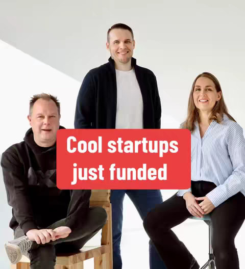 The image features three people standing in front of a white background. A text overlay in a red rectangle reads, "Cool startups just funded". The person on the left is wearing a black hoodie and sneakers. In the middle is a man wearing a navy blue jacket over a white shirt and jeans. The woman on the right is wearing a light blue button-down shirt and black pants.  They each have a different expression, but all are smiling. The composition appears to be a studio shot designed for promoting a startup.