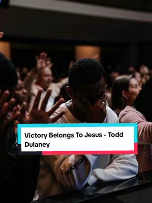 The image shows a group of people, likely a church congregation, with a man in the foreground covering his face with his hands with other hands in the air. A text overlay on the image reads: “Victory Belongs To Jesus - Todd Dulaney” The composition features a vertical orientation.