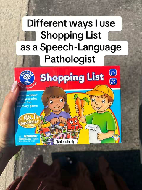 The image shows a woman's hand holding a "Shopping List" game box by Orchard Toys. The box is positioned over a light gray surface, possibly concrete, with a blurred background. The box features animated children with a shopping cart from a game in progress. Text overlays at the top highlight the video's focus on  using the game for speech therapy.