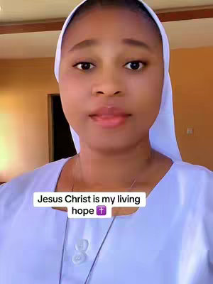 A woman wearing a white head covering and white top looks directly into the camera. The background is blurry, with a warm, neutral palette. A white text box at the bottom reads, "Jesus Christ is my living hope" in white text, with a purple cross graphic.