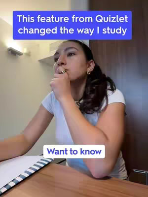 A woman sits at a desk, pensively touching her finger to her lips while looking off to the side. A text overlay appears in a blue box above her head. Below a second text overlay in a white box appears. There is a desk with a white paper in front of her.