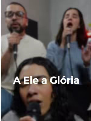 The cover image features three individuals singing into microphones. A woman is prominently featured in the foreground, with her face and a microphone in focus and the text "A Ele a Glória" overlaid. Two additional figures are visible in the slightly blurred background, also singing, suggesting a group performance setting.