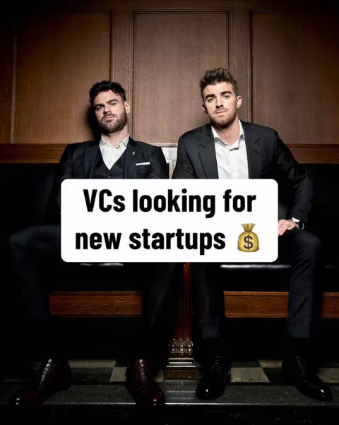 Two men in suits sit on a wood bench. A white rectangle overlay with the text 'VCs looking for new startups' is in the foreground. A money bag emoji is next to the text. The background includes wooden panels.
