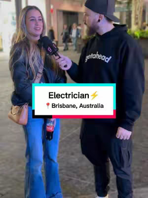 A cover image showing a man and a woman being interviewed on the street. The woman is holding a black microphone and the man is holding the microphone. A title card in the middle of the image shows text about an electrician in Brisbane and the location.