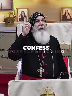 A medium shot of a man with a white beard in religious attire speaking to the camera. The background includes framed pictures and religious decor.