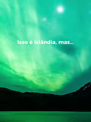 A vibrant image shows a green aurora borealis illuminating the night sky. Below, dark silhouettes of mountains and a body of water complete the bottom part of the image. Text overlayed on the aurora reads, 'Isso é Islândia, mas…' in white font.
