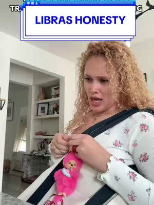 A woman with curly blonde hair is looking slightly off-camera with a concerned expression. A text overlay reads 'Libras Honesty'. She is wearing a white top with a floral pattern and a baby carrier holding a pink plush toy.