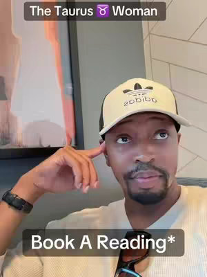 A man wearing a backwards Adidas cap and a white shirt looks up with a contemplative expression, resting his index finger on his temple. Overlay text at the top reads 'The Taurus Woman', with the Taurus symbol. At the bottom, the text 'Book A Reading*' is overlaid.
