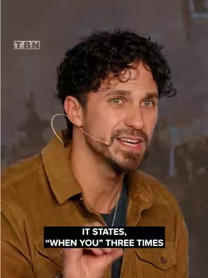 The cover image is a medium, slightly upshot of a man with curly black hair and a beard. He's wearing a brown shirt with a black undershirt and a microphone. There's a text overlay at the bottom that quotes lines, "IT STATES, \"WHEN YOU\" THREE TIMES."