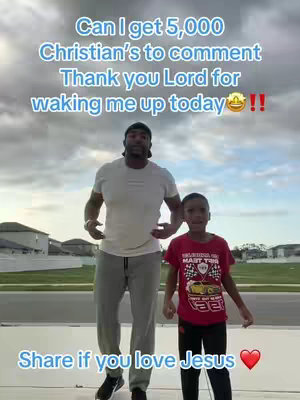 A man and a young boy are posing outdoors on a sunny day with text overlays. The man is wearing a white t-shirt, grey sweatpants, and a black cap. The boy is wearing a red t-shirt with a graphic, black pants, and sneakers. Behind them is a slightly cloudy sky and some houses. The text overlay asks for Christian's to comment and share if they love Jesus.