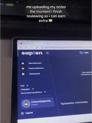 The cover image is a screen recording of a laptop displaying the Sapien website or app. The screen is mostly blue with white text and icons on the left. The top of the screen has the title "Sapien". Below this are icons and text for different sections like Task Dashboard, Points Dashboard, and Training Hub. In the bottom part of the screen, there is a profile circle with the name "CrimsonDolphinHL" and the language "English". On top of the screen there is a text overlay in white font which has the hook for this video. Below the surface of the laptop screen some of the upper part is visible. The background is black.