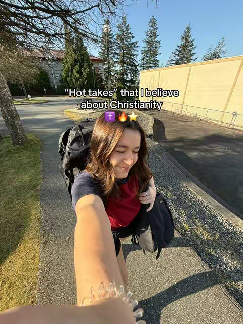 A selfie-style shot from an outdoor setting. The focus is on a young woman, who is smiling and holding the camera at an upward angle, showing her arm and some details of the foreground. The background features a building and trees, with a bright sky. The foreground includes a glimpse of the person's arm, displaying a clear bracelet, adding a personal touch. The image is lit with natural sunlight, giving a warm and inviting feel. The overall composition uses a diagonal perspective, adding depth to the shot, and the image has some text overlays. 