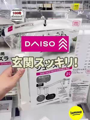 The cover image features a hand holding a product package in a store setting. The package is for a "Shoe Rack for Extendable Rod" from Daiso. The background shows store shelves with various products. The image has a bright and clean aesthetic, with a focus on the product and its packaging.