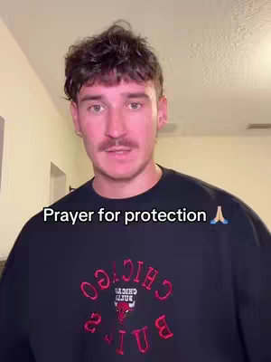 A medium shot features a man facing the camera. He has short, dark brown hair and a mustache. He's wearing a black Chicago Bulls sweatshirt. The text overlay reads, "Prayer for protection" in white letters with a praying hands emoji.