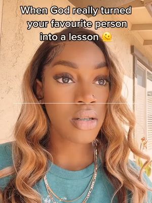 The image is a close-up of a woman with brown skin, light-brown and blonde wavy hair, and is wearing a turquoise shirt. The woman has a serious yet surprised expression, looking slightly off to the side. Above the woman's face, there is text on a light background, which appears to be an overlay.