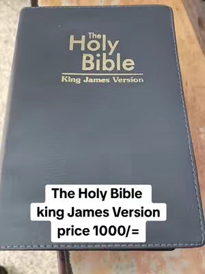 The image shows a Bible on a wooden surface from a slightly angled perspective. The Bible is dark with gold lettering. A white rectangular overlay at the bottom of the cover states the item's name, version, and price.