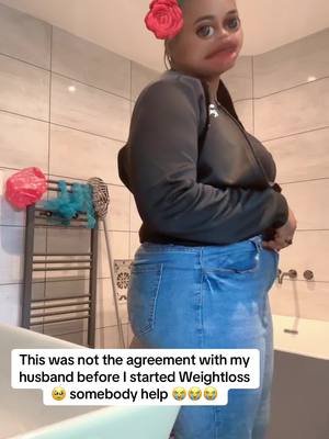 A woman stands in a bathroom, viewed from the side, wearing blue jeans and a black zip-up jacket. She has a red rose pinned to her hair and a filter is applied to her face. The text overlay conveys a humorous sentiment.