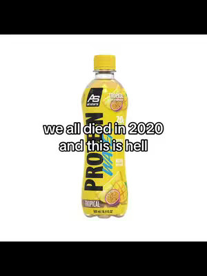 The image is a bottle of AS ALL STARS Protein Water. The bottle is the primary focus, centered against a stark white background. The bottle is a vibrant yellow, with a label featuring the brand name, the words "Protein Water" in large letters, and a graphic including slices of mango and passion fruit. The product is positioned vertically, with the cap at the top. Below the bottle, overlaid in all white text, text that says 'we all died in 2020 and this is hell'.