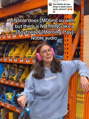 A young woman stands in a hardware store aisle, leaning against shelves stocked with various hardware and tools. She's wearing a blue hoodie and pink headphones. Text overlays are present on the image.