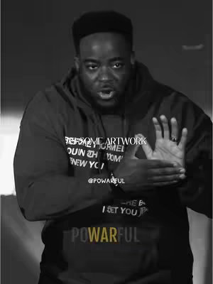 A black and white image of a man in a hoodie, gesturing with his hands and looking directly at the camera. Text overlays include the word POWARFUL and a username, along with text on the hoodie and the phrase 'Discernment isn’t for us to criticize🧠'.