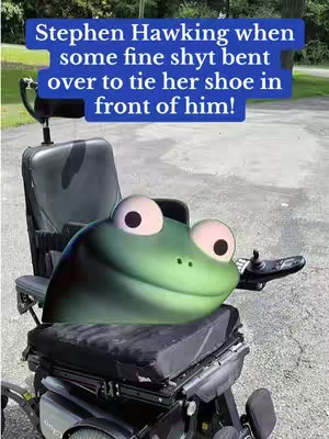 A digitally altered image shows a green cartoon frog head superimposed on an electric wheelchair. Above the frog's head, in a blue rectangular text box, is the text: "Stephen Hawking when some fine shyt bent over to tie her shoe in front of him!". The frog's eyes are large and round with pink circles surrounding them; the frog appears to be looking to the side. The wheelchair is black and silver, set outdoors with a portion of a paved area and some out-of-focus greenery visible in the background.