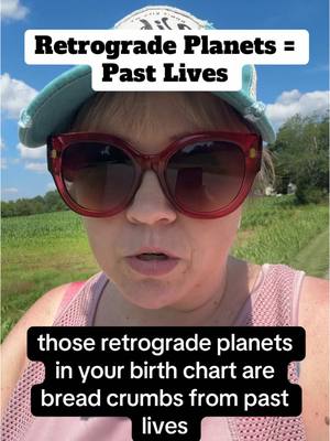 A woman wearing large sunglasses and a hat is in a selfie video, set against a background of blue sky and green fields. Text overlays are present at the top and bottom.