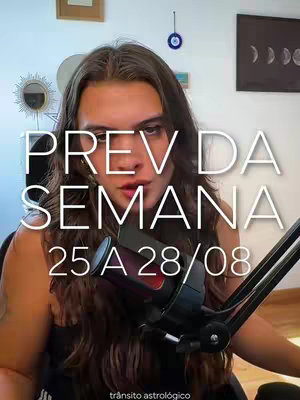A young woman with long brown hair is centered, looking towards the camera with a serious expression. Overlaid on her is large white text: "PREV DA SEMANA" above "25 A 28/08." In the background, a microphone is visible, along with a diverse array of decorative items like a decorative mirror and abstract art on the wall. The lighting appears natural, and the overall composition gives a feeling of astrology and weekly forecast.