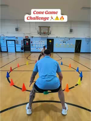 The cover image features two men in a gymnasium, one facing the camera from the front, the other in the background. Both are wearing athletic attire, with one focused on a circle outlined by traffic cones. The overhead text in a rectangular bubble says "Cone Game Challenge" with action figure icons and flame emojis.