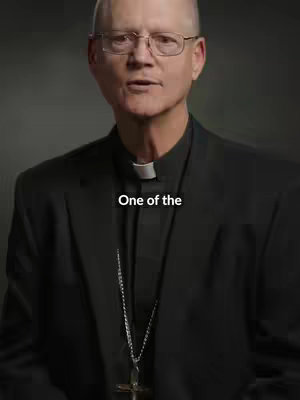 A man in a black suit and clerical collar speaks, appearing to be in a studio environment. The text overlay reads, 'One of the'.