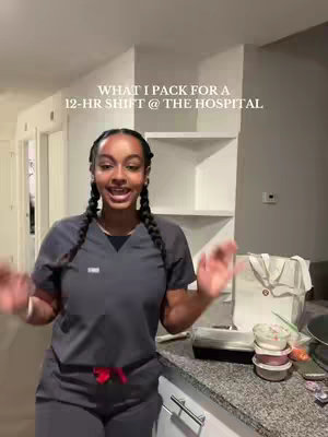 A woman in scrubs stands in a kitchen, talking. Text overlay reads, "WHAT I PACK FOR A 12-HR SHIFT @ THE HOSPITAL." Various food containers and a tote bag are visible on the counter.