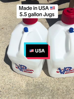 The image showcases two white 5.5-gallon fuel jugs with red caps and blue spouts, side-by-side. The jugs have a curved rectangular shape and the VP Racing logo is visible on the bottom. Text overlays read 'Made in USA' with a small American flag and '5.5 gallon Jugs,' alongside another rectangle with 'USA' and the flag.