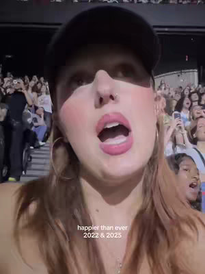 A close-up shot of a woman wearing a black baseball cap. She has large gold hoop earrings and her face is flushed. Her mouth is open as if she is singing and there is a crowd of people in the background. Text overlayed says "happier than ever 2022 & 2025".