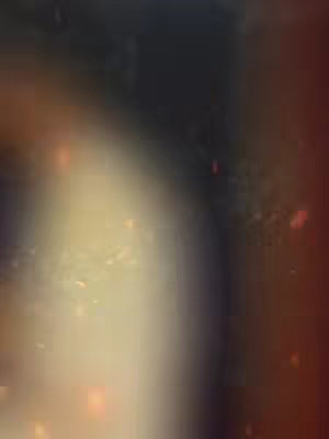 Abstract image with an out-of-focus, blurry effect. The color palette is dominated by warm tones, including soft yellows, oranges, and deep browns. There are hints of light speckles or particles scattered across the image, suggesting a sense of depth or a celestial theme. The overall composition lacks sharp detail, giving it a dreamlike or ethereal quality.