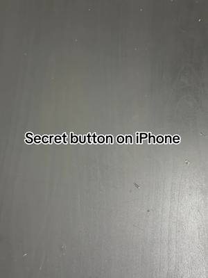 A close-up shot of a gray, textured surface. Superimposed on top is the white text: "Secret button on iPhone". The text has a clean, sans-serif font and is positioned in the center.