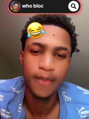 The cover image is a selfie featuring a young man with a medium complexion. He is wearing a blue shirt with a white 'PUMA' pattern. He has short, dark, curly hair, and his facial expression is one of amusement. Overlayed on the image are elements common in social media, including a circular profile pic and a search bar at the top with the text 'who bloc,' along with a laughing emoji positioned near his forehead to further add to the humorous effect.