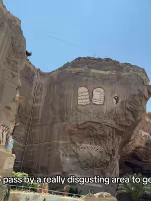 The cover image shows a large, weathered rock face with inscriptions and carvings. Two panels with text stand out, and the blue sky fills the upper portion of the frame. The environment suggests an outdoor, possibly historical site.