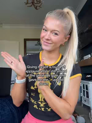 A light-skinned woman with blonde hair pulled into a high ponytail is smiling while clapping her hands in front of her chest. Text is overlaid on the image.