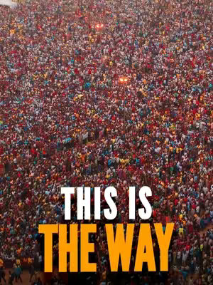 An aerial shot of a crowd of people, tightly packed together, with various colors of clothing. The words "THIS IS THE WAY" are overlaid prominently in white and orange.