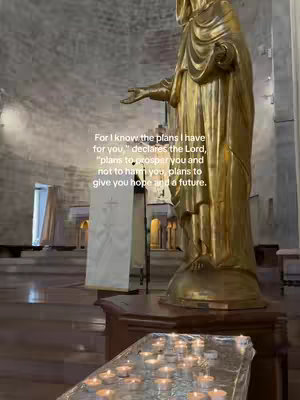 The cover image features a golden statue of a religious figure in a church setting. Text overlay in the center provides a Bible verse.