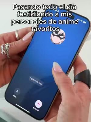 A person holding a smartphone showing a video call interface, the background is blue. The person is wearing rings and their nails are painted in long light nails. The framing and angle emphasize functionality: it's a clean shot.