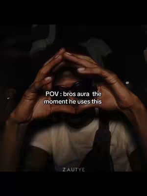 The image is dark, featuring a person framed by their own hands in a triangular pose in front of the face, with text overlaid and the image appears to be captured from a slightly low angle.