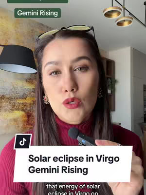 A woman with glasses on her head, looking into the camera. Text overlays state the video topic: Solar eclipse in Virgo Gemini Rising, with additional text: Gemini Rising.
